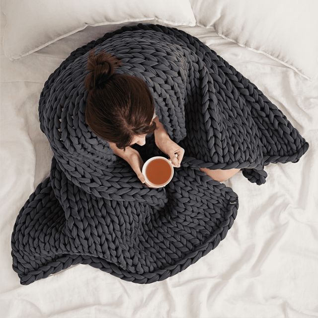 women wrapped in bearaby grey blanket