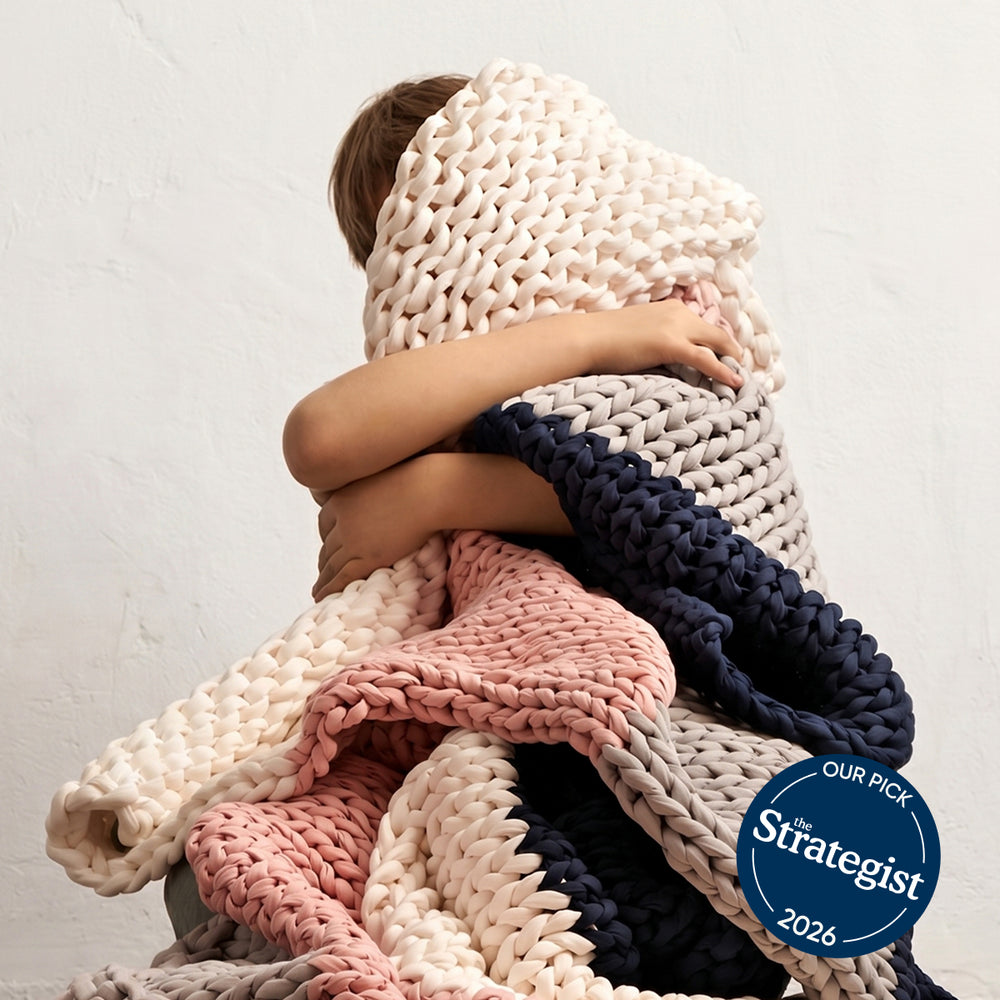 Children wrapped in a bearaby chunky knit kids blanket with 'The Strategist' 2026 pick badge.