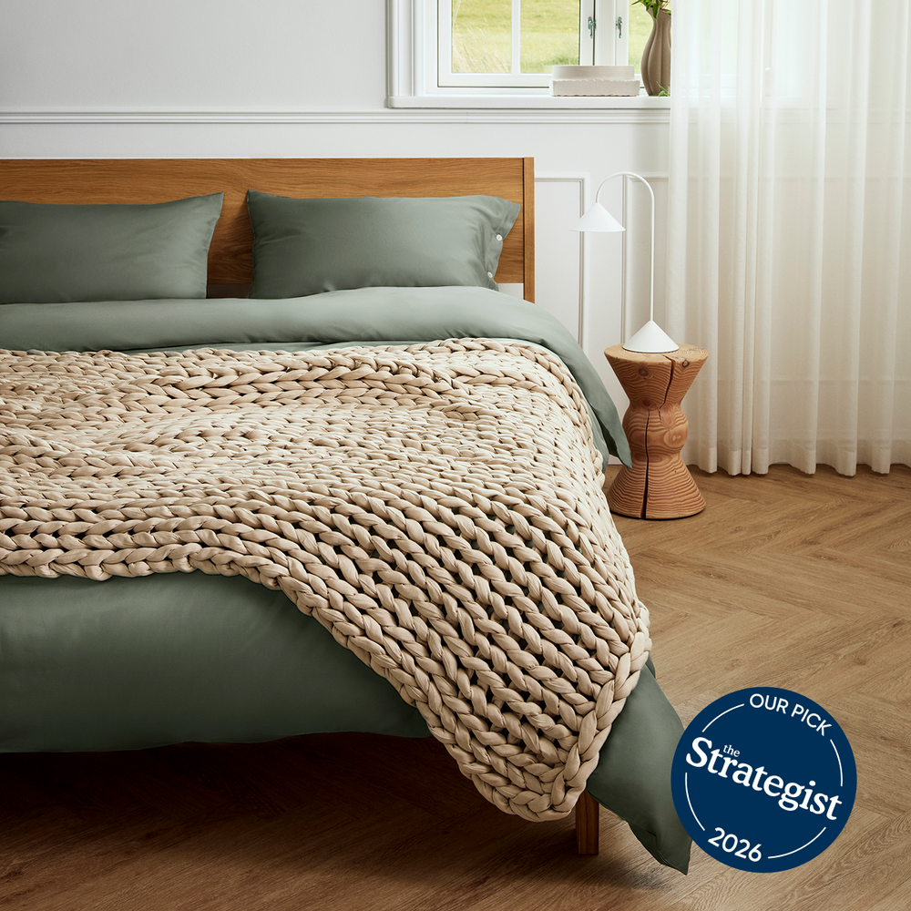 Driftwood bearaby knitted blanket on a bed in a bedroom with 'The Strategist' 2026 badge.
