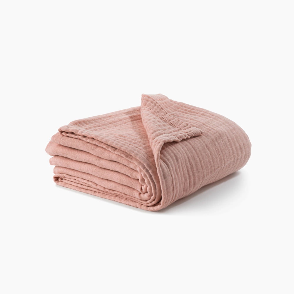 folded view of muslin cocoon throw blanket pink