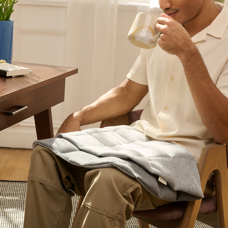 Using the weighted lap pad while seated in a chair
