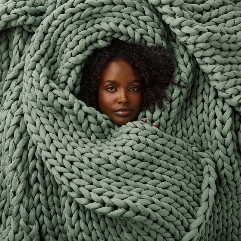 Person wrapped in a Morning Matcha  knitted blanket