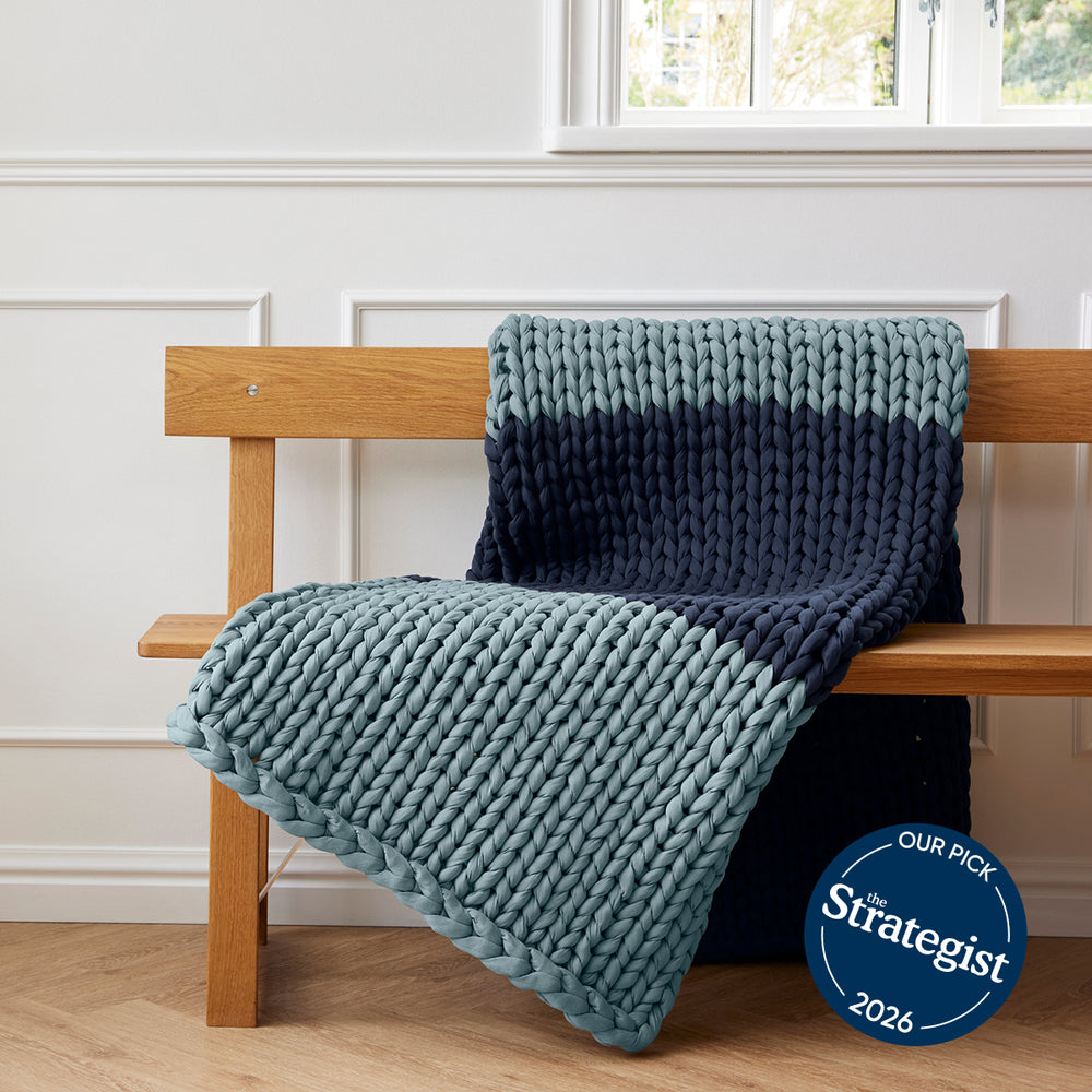 Bearaby Knitted blanket draped over a wooden bench with 'The Strategist' 2026 badge in the corner.