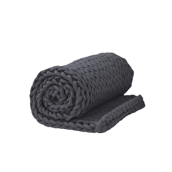 YnM weighted blanket draped across queen bed in a warm-climate bedroom with fan and linen sheets to illustrate real-use setup