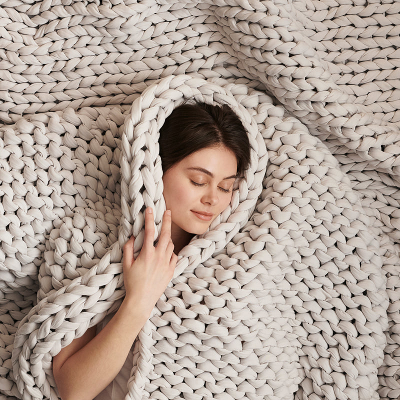Lady about to fall asleep under woven weighted blanket